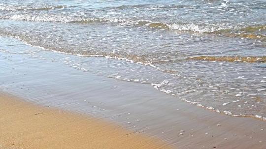 夏天的海边海滩上波浪泛起朵朵浪花慢镜