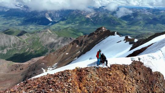 航拍登顶沙鲁里山脉尼登贡嘎雪山的登山者