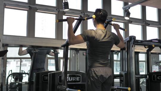 男子在健身房使用器械锻炼引体向上视频素材模板下载