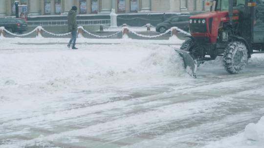 清晨环卫工人开着铲雪车清除路面积雪