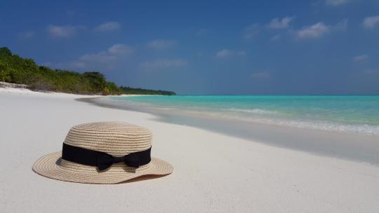 沙滩上的帽子和水蓝色的海水