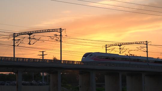蓝天夕阳下行驶的高铁动车