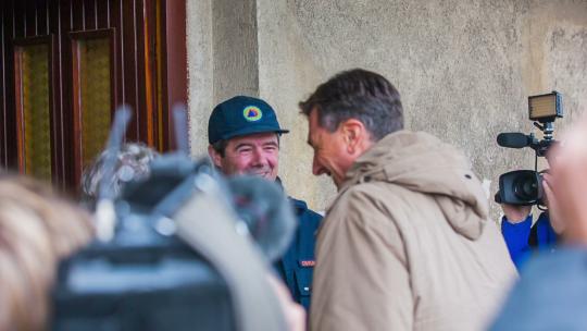 斯洛文尼亚塞克尼卡——2014年10月：斯洛文尼亚总统博鲁特·帕霍尔看望老夫妇。大洪水后斯洛文尼亚总统的特写镜头，参观该地区洪水受害者的家。