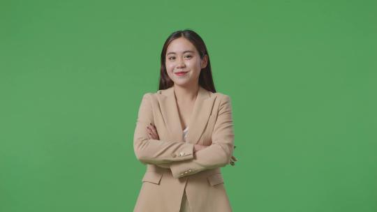 亚洲商业女性交叉手臂和温暖的微笑在绿屏背景在工作室