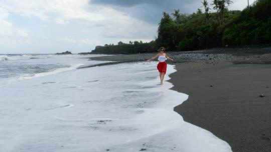 在海滩上奔跑的年轻女子
