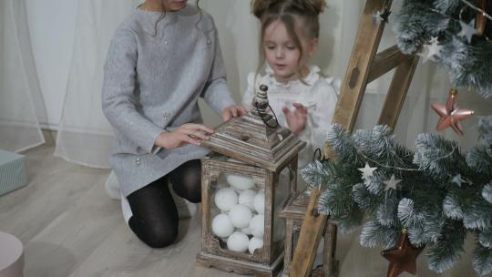 两个小女孩在圣诞树下玩耍