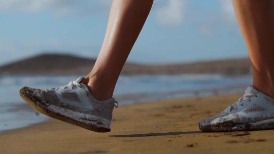 海边穿着运动鞋散步的特写