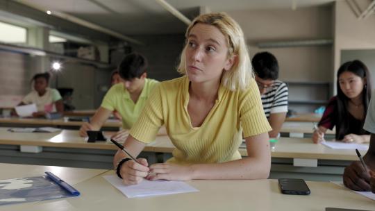 女人在课堂上听课做笔记