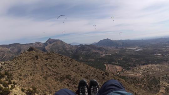 4K滑翔伞运动飞行在蓝天白云草地树林间