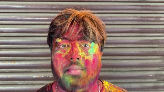 一个印度男孩用彩色庆祝胡里节的特写镜头