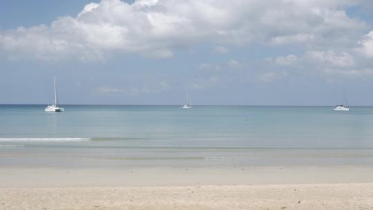 白色的沙滩和波浪从平静的大海在阳光明媚的白天