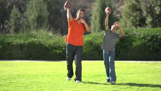 一位父亲教他的儿子如何踢美式足球