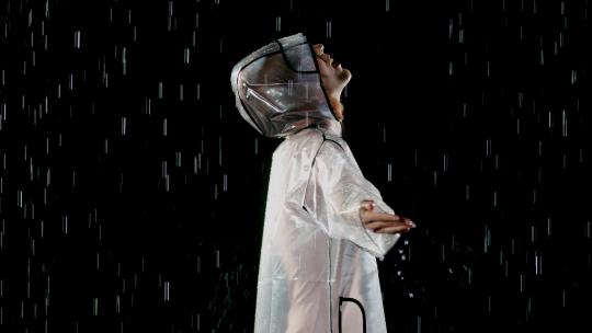 身穿雨披的女人在雨中跳舞