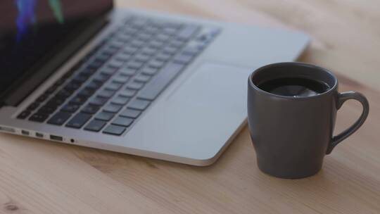 黑咖啡饮料旁边的银色Macbook笔记本
