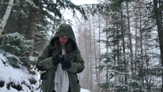 女孩在下雪的树林里拍照