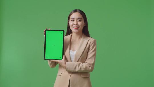 女商人在绿屏上展示平板电脑