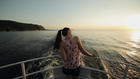 女孩站在船头看着大海天空