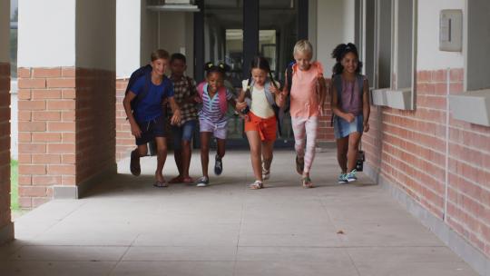 快乐的不同学生在学校走廊上奔跑的视频