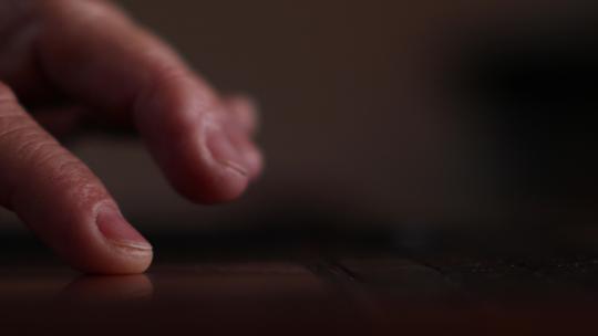 屏幕背光笔记本电脑触控板上人类手指滚动的特写