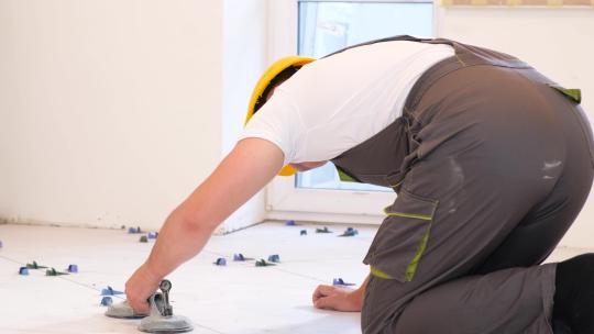 一名男性建筑工人安装一块大瓷砖视频素材模板下载