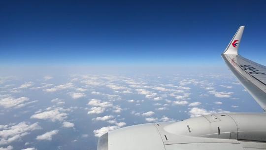 飞机飞行在云层之上透过舷窗俯瞰祖国大地