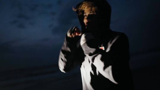 黑暗中在海滩边训练的女拳击手