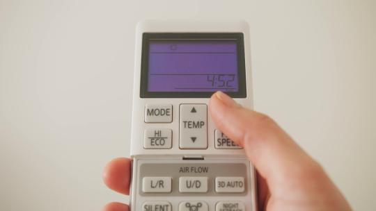 带遥控空调的手动调节空调温度以获得舒适视频素材模板下载