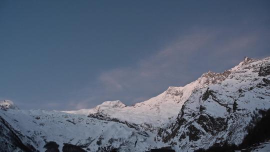 瑞士阿尔卑斯山的日出，萨斯费当太阳照亮雪山之巅时的延时视频素材模板下载