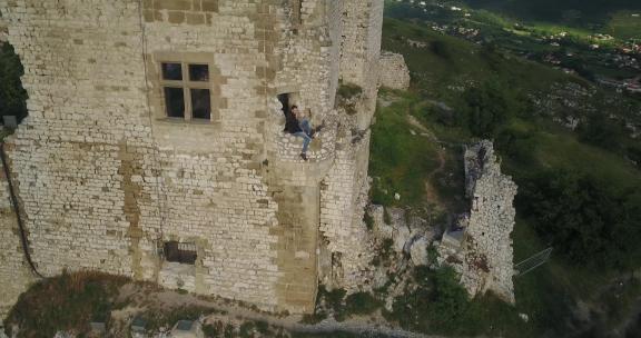男人危险地坐在城堡之旅的边缘
