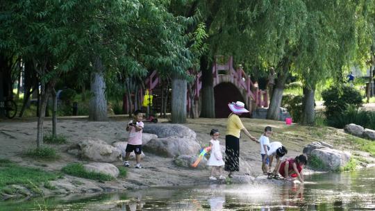 在公园河边玩耍嬉戏的孩子们