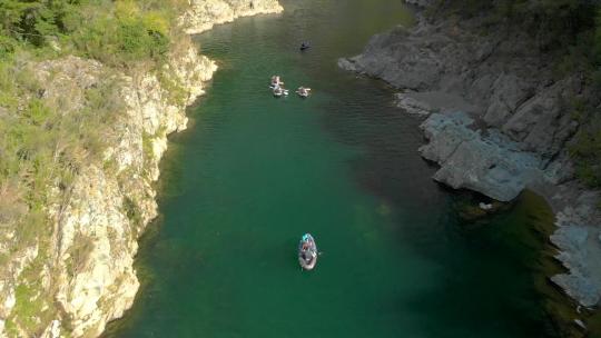 独木舟旅游中的人划桨美丽原始清澈的蓝色佩鲁斯河，新西兰——无人机