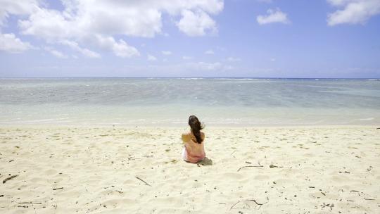 坐在沙滩上看海的女孩