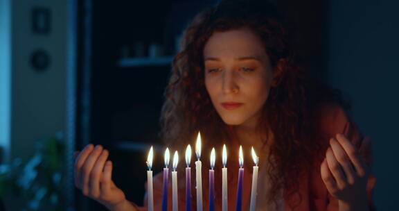 一个红头发的女人用点燃的蜡烛做犹太传统仪