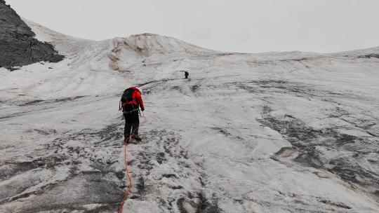 冰川上攀登甘孜党龄主峰夏羌拉雪山的登山者