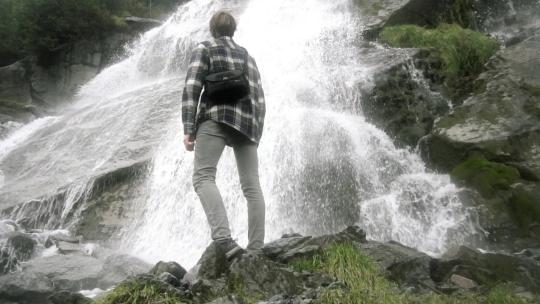 一名男子站在美丽的瀑布前