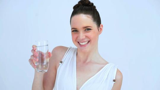 微笑的女人喝一杯水