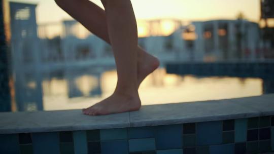 日落时女孩在游泳池边散步视频素材模板下载
