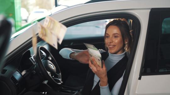 一个女人坐在车里扔钞票