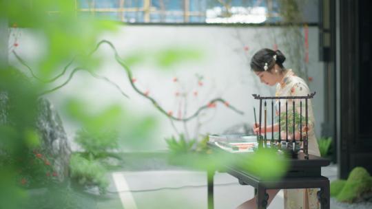旗袍美女在别墅写毛笔字