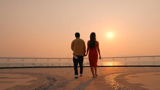 温暖浪漫晚霞下亲密无间的情侣背影特写