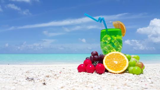 放在沙滩上的水果和饮品