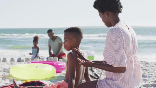 快乐的非裔美国家庭躺在海滩上大笑的视频视频素材模板下载