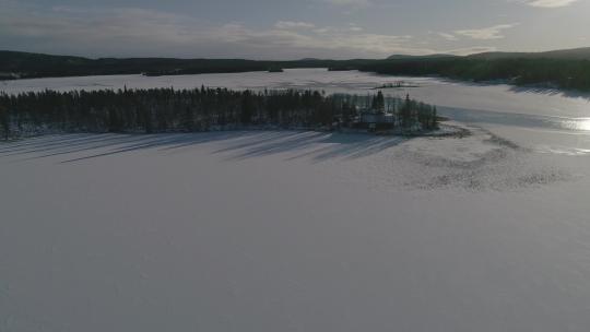 航拍阳光下的湖泊和雪域林地视频素材模板下载