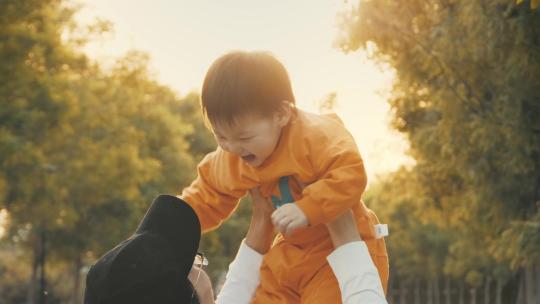 阳光下爸爸举起孩子婴儿学习走路父亲节