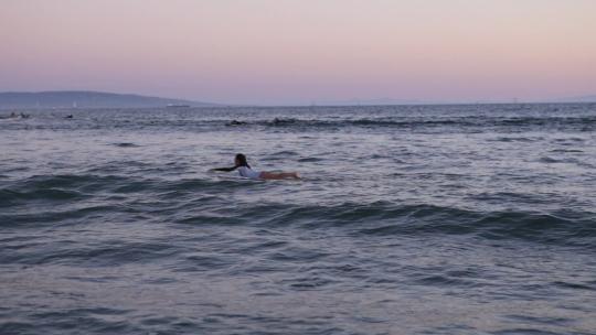 一个女人在海面上用冲浪板冲浪